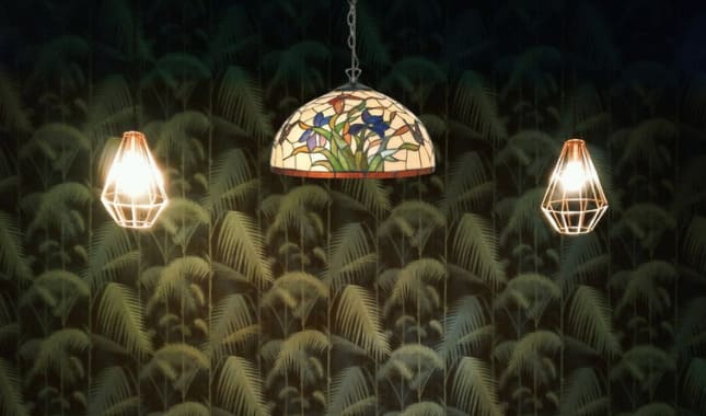 Lustre en plumes éclairé, suspendu avec trois lampes, murs décorés de motifs feuillagés. comment nettoyer un lustre en plumes intégré discrètement pour entretien et raviver les plumes.