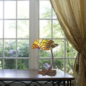 Lampe Tiffany abat-jour stained glass sur socle en bois près d’une fenêtre, lumière naturelle et rideaux dorés. luminaire tiffany consommation électrique intégrée.